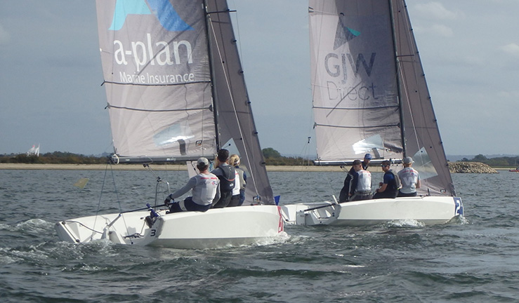Two RS21 keelboats close racing bow to transom upwind with the sun out at the RYA Summer Match Racing Q2 event at Queen Mary SC, 2023.