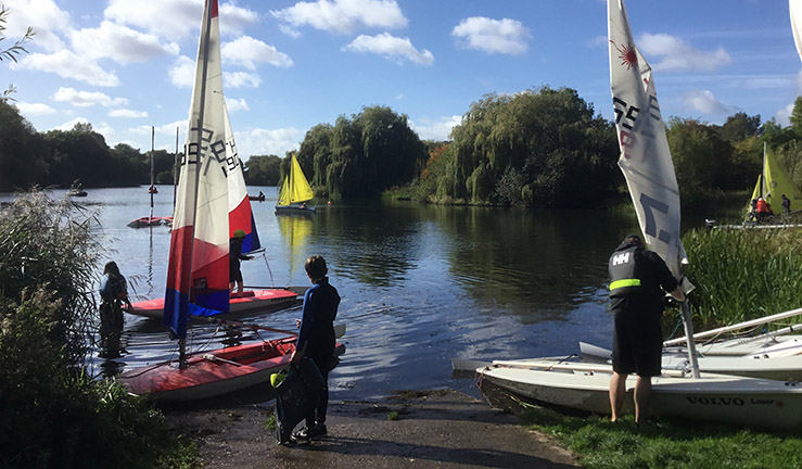 Idyllic view over the John Merricks Lake in Leicestershire on a sunny day with blue skies and clouds in the sky, with sailing dinghies on shore and on the water with LRYSA.