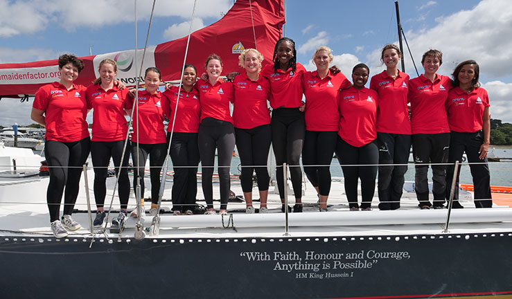 Maiden crew wearing team red shirts lined up on deck of the boat.