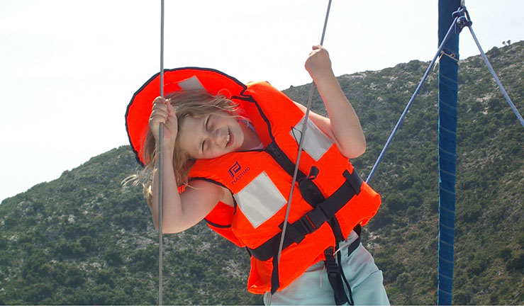 Heather Thomas as a young girl smiling for the camera in a children's life jacket on a yacht / flotilla holiday with family.
