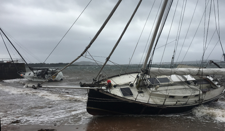 Yachts lying on the beach after a summer storm - Climate Changes