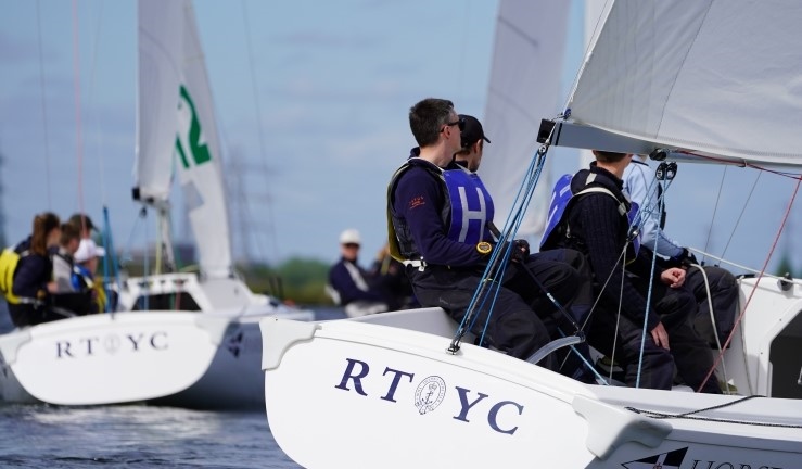 Close up view into a team racing a Sonar at a previous edition of the Carmela Cup with another two boats upwind. 