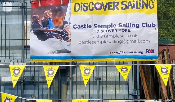 Groups of people out on the water at Discover Sailing at Castle Semple on a bright, cloudy day.