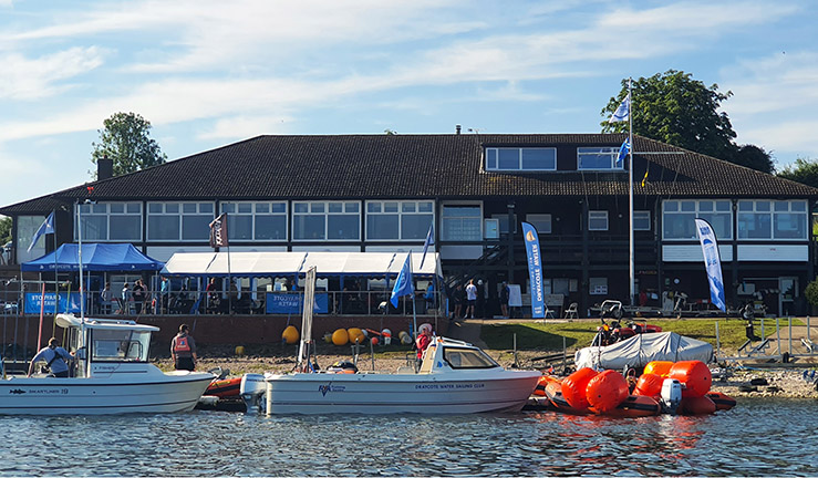 View of Draycote Water SC clubhouse from the water with committee boats and RIBs.