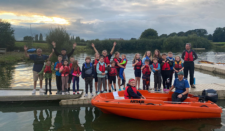 Group of around 20 juniors smiling on the jetty at Gresford Sailing Club.