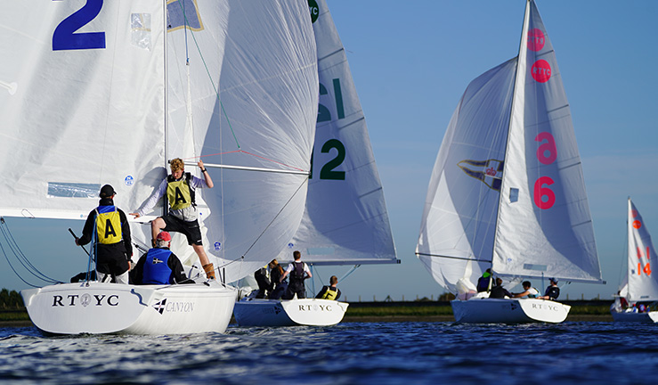 Four Royal Thames YC's Sonars sailing downwind with spinnakers flying, with the crew in the keelboat nearest to the camera pushing out the spinnaker pole. Blue skies and sunshine!