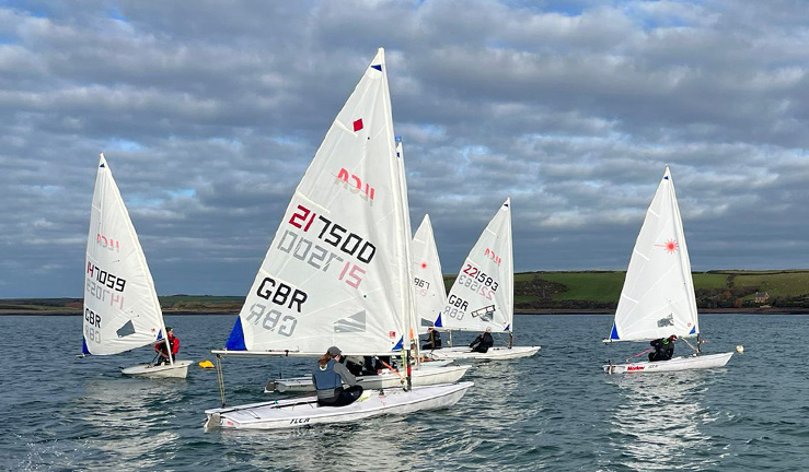 Group of five Welsh squad ILCA sailors on the water training on a winter's day.