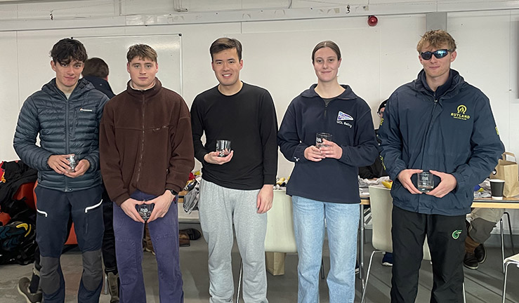 Skipper Ben Tylecote (right) with his team of four crew holding prizewinning glasses in the clubhouse at Queen Mary SC, Qualifier 1 of RYA Match Racing Series.