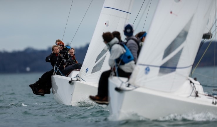 Two J70 keelboats racing upwind with British Keelboat Academy crews leaning out over the side.