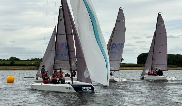 Eventual winners of the British Keelboat League at Rutland 2024 hoisting their spinnaker after leading the RS21 fleet around the windward mark in one of the races.
