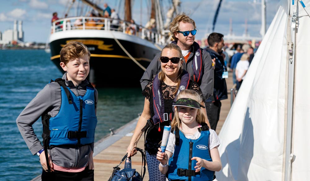 family smiling on pontoons at southampton international boat show