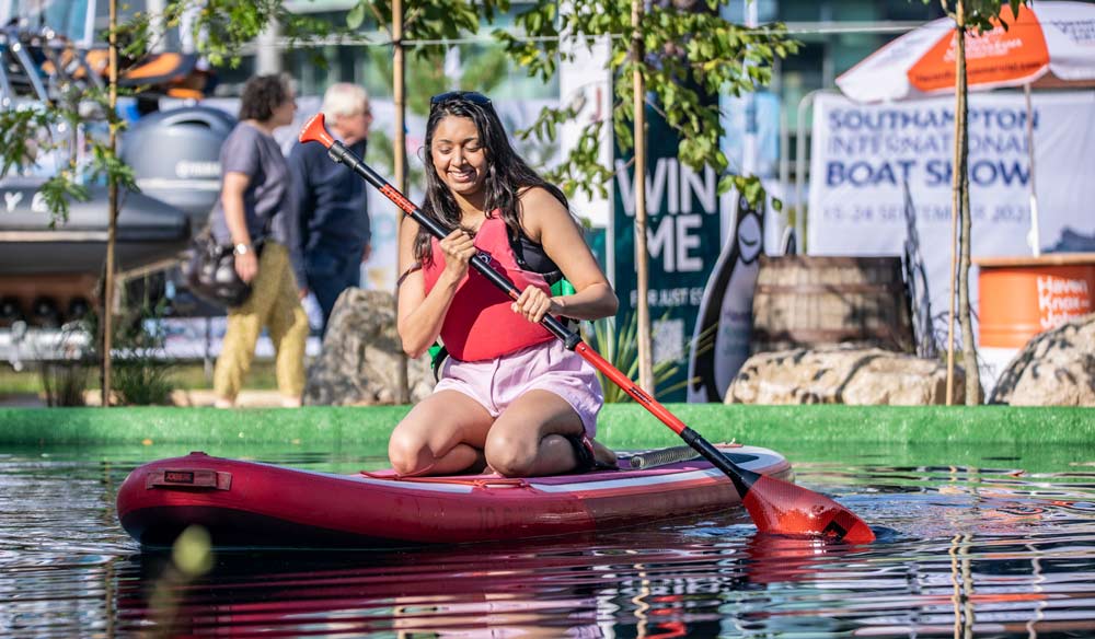 woman kneeling on paddleboard at southampton international boat show