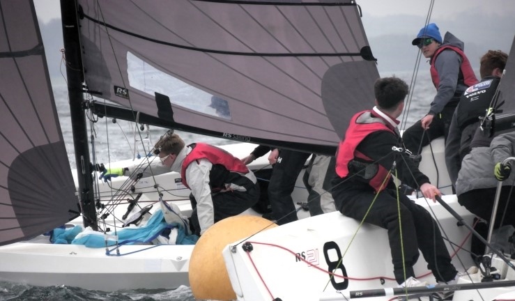 Close of up two RS21 keelboat teams rounding a mark at close quarters.