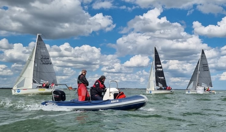 Three SB20 keelboats and a blue RIB on a sunny day with blue skies and fluffy clouds for Qualifier 4 of the British Keelboat League on the Blackwater Estuary.