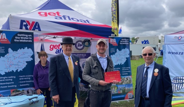 RYA Midlands stand at Staffordshire County Show, where Burton & Blithfield Sailing Clubs won 'best stand' - picture shows presentation of red 1st place certificate from show judge in bowler hat.