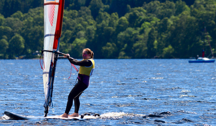 A young sailor competing in the RYA Scotland youth and junior championships On a wind surfing board.