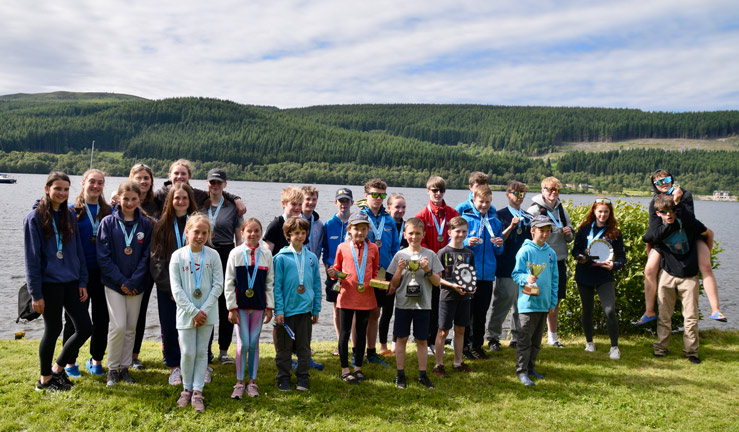 young sailors who competed in the RYA Scotland youth and junior championships with their medals and trophies in a group photo.