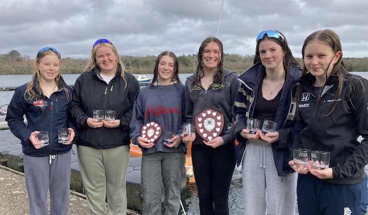 RYA/BUSA Women's Team Racing Nationals winners - team of six pupils from Royal Hospital School on the shore at Spinnaker Sailing Club, holding a glass each and the Under-19 and national championship trophies after winning both titles!