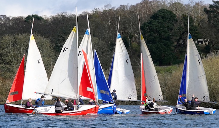 Six Firefly dinghies - three with blue jibs and three with red jibs - team racing in sunshine on the lake at Spinnaker SC for the RYA national championship.