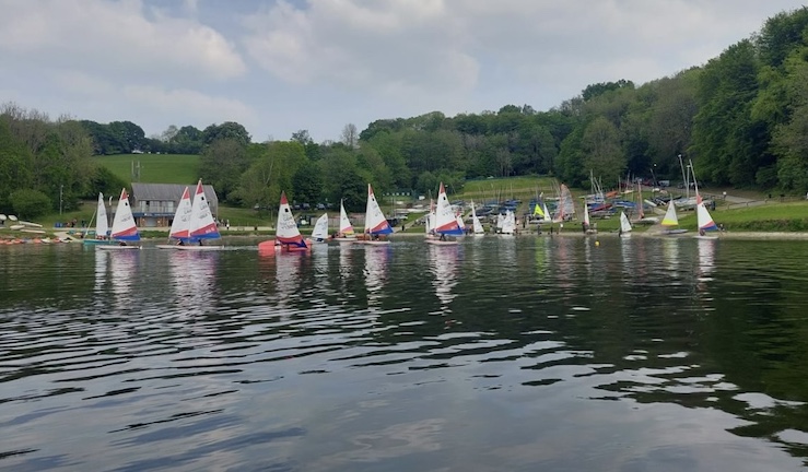 Lots of dinghies on the lake with clubhouse and hill backdrop at Llandegfedd Sailing Club.
