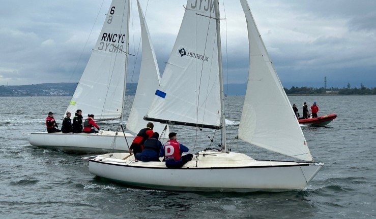 Two teams racing Sonar keelboats for the Ceilidh Cup 2024 at Royal Northern & Clyde YC on a grey day with umpire boat in the background.