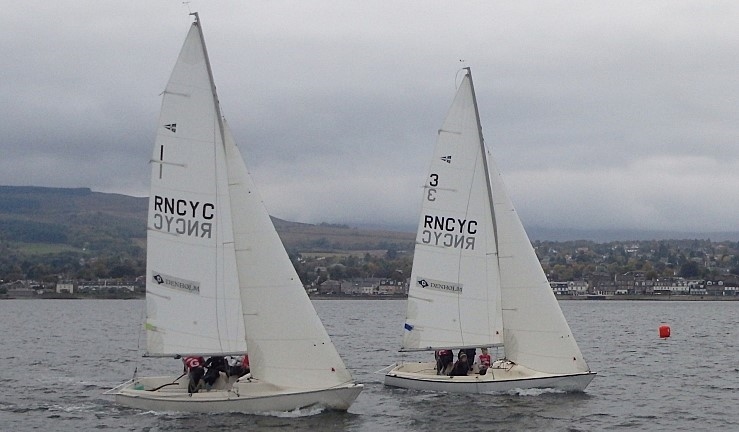 Two teams racing Sonar keelboats upwind on a grey day with shoreline in the background, Ceilidh Cup 2024 at Royal Northern & Clyde YC.