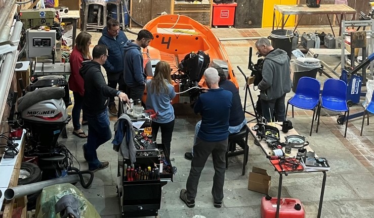 People taking part in an indoor powerboat maintanance workshop at Plas Menai as part of the Big Weekend 2024.