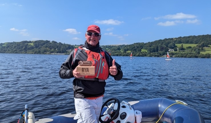 Mick Flemming on the water at Bala SC in a RIB on a sunny day receiving his RYA CW Impact Award.