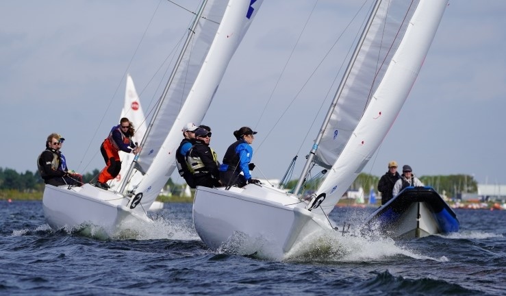 Two teams upwind racing Sonar keelboats with Royal Thames YC with a RIB alongside at London's Queen Mary SC.