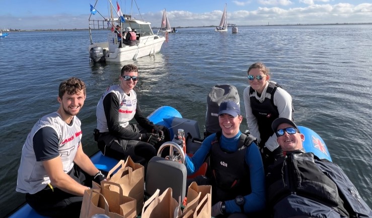 Sailors relaxing in the sunshine on a blue RIB between races at the RYA National Match Racing Championship Grand Finals 2024 at QMSC.