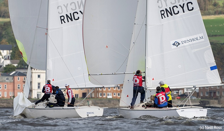 Two teams in red bibs match racing Sonars with white sails and spinnakers downwind at the Ceilidh Cup in Scotland.