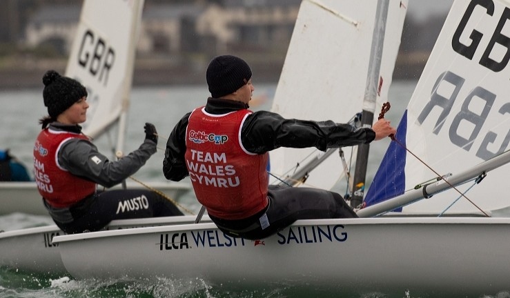 Two of Welsh Sailing's ILCA sailors competing at the Celtic Cup 2025 wearing red branded team bibs.