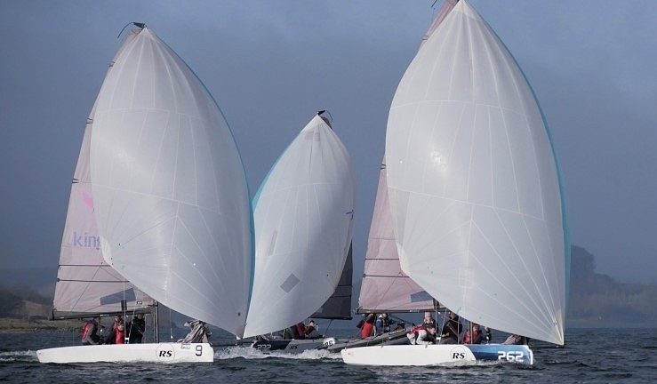 Three teams racing RS21 keelboats downwind with white spinnakers flying at Rutland Sailing Club.