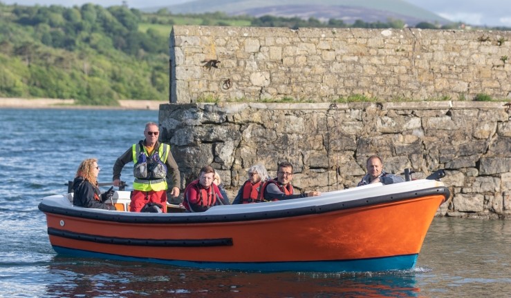 Half a dozen people enjoying a trip aboard a powerboat with SEAS Sailability. 