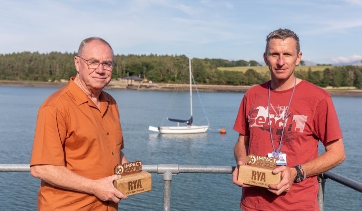Richard Horovitz and Jon Gamon, who founded and continue to volunteer for SEAS Sailability in North Wales, by the water with their RYA Cymru Wales Impact Awards.