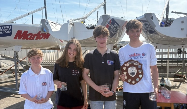 RYA Harken Youth Match Racing Championships 2025 - Alex Vollmer with his winning U-19 team and prizes on shore in front of British Keelboat Sailing's Elliott 6M fleet.