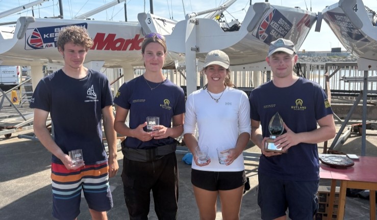 RYA Harken Youth Match Racing Champions 2025 - Jamie Tylecote with his winning team and prizes on shore in front of British Keelboat Sailing's Elliott 6M fleet.