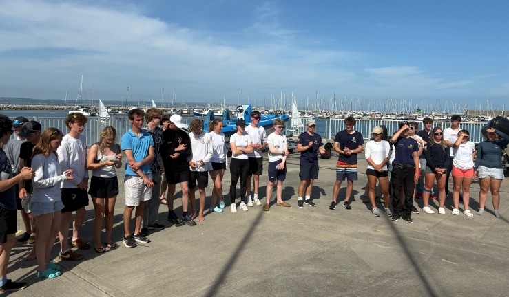 Competitors gathered on shore in sunshine and blue skies at WPNSA at the RYA Harken Youth Match Racing Championships 2025.