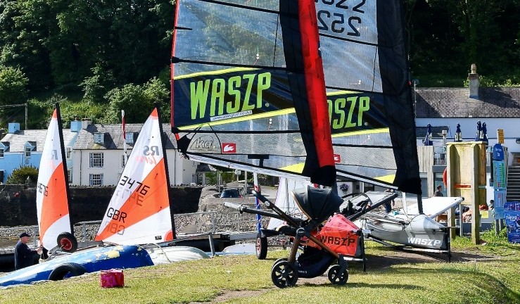 Image of a Waszp foiling dinghy on shore along with a couple of RS Tera junior boats with sails up at the RYA Cymru Wales Regional Junior Champs, Dale, 2024.