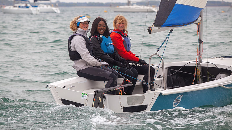 wide shot of three sailing dinghy out at sea