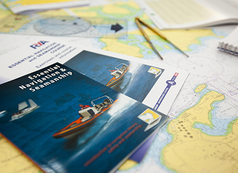 Essential Navigation course materials laid out on a table with charts and training materials