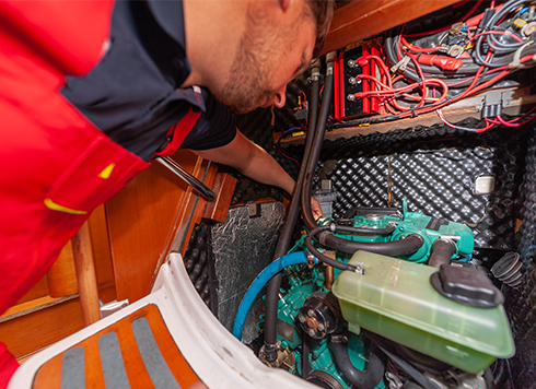 Man looking at diesel engine on a sailing yacht