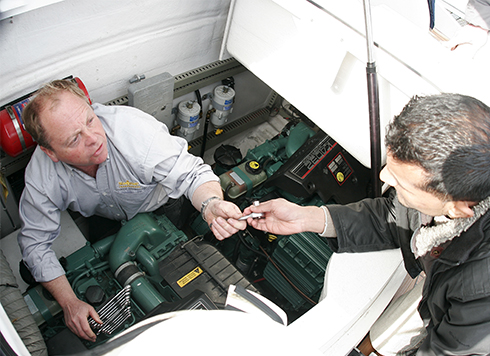 Two men working on diesel engine together