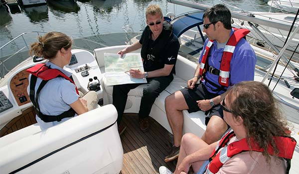 RYA Day Skipper Motor course. Training on deck, looking at charts and doing chartwork. 