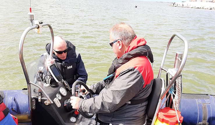 Dave Kelly (in red) on the helm of the RIB with Phil Hastain (in black) 