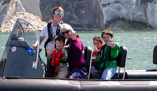Family on RIB all waving and smiling at camera