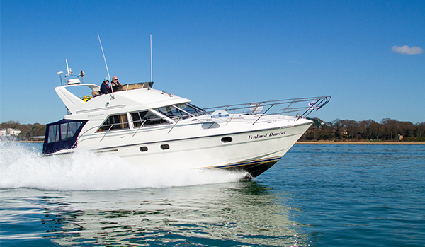Motor boat cruising at coastal location, flat water blue skies