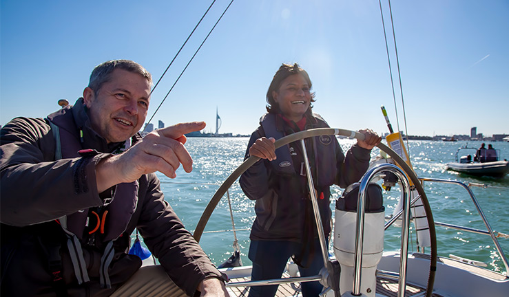 Woman learning to sail at the helm of a yacht