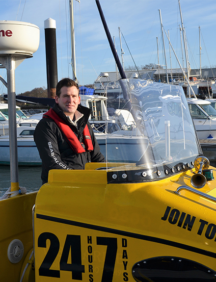 Sea Start marine engineer stood at helm of yellow boat