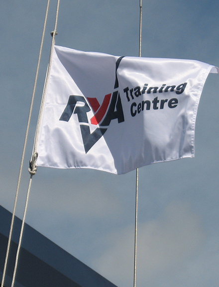 RYA training centre tick mark logo white flag flying against blue sky